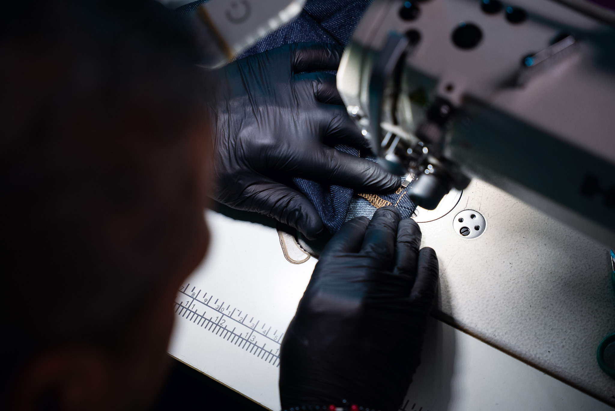Over the shoulder: a seam being finished by hand and machine.